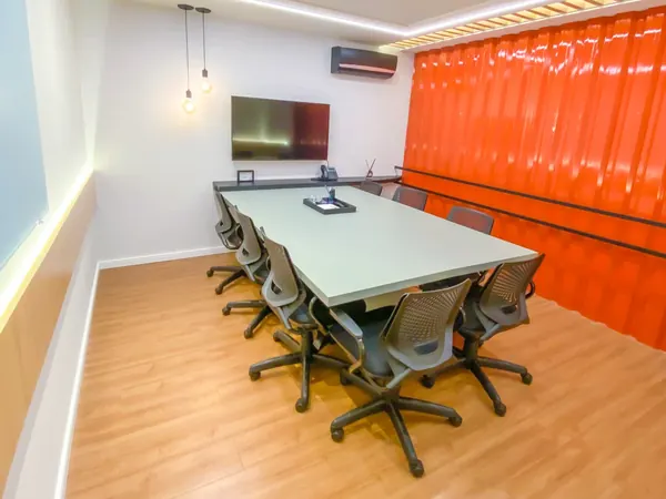 Sala de reunião com TV e mesa para oito pessoas