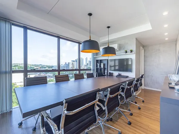 Sala de reunião com mesa para dez pessoas e vista para a cidade